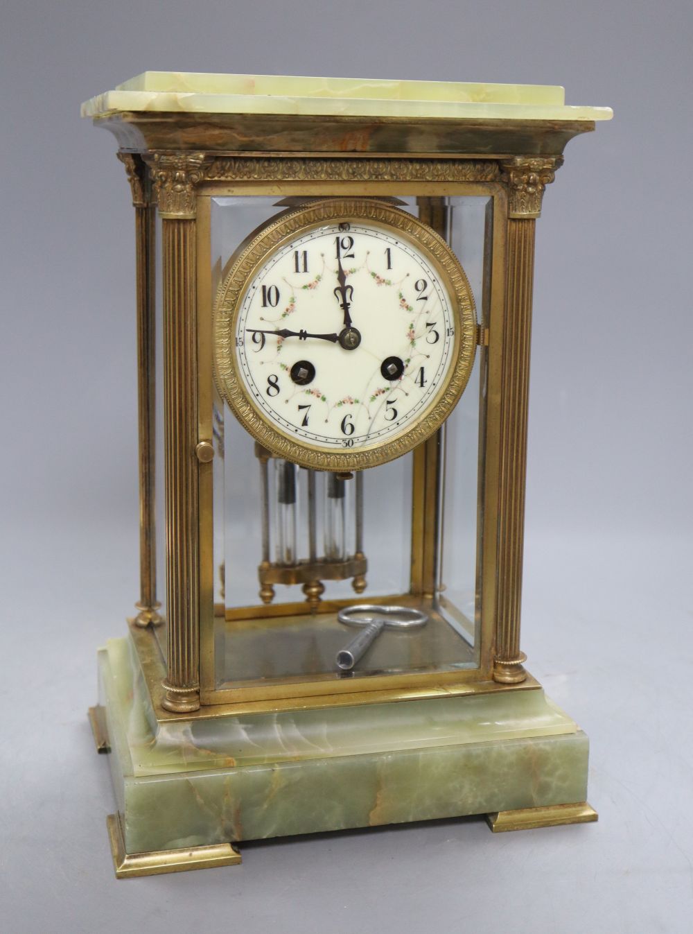 A four glass onyx and brass Corinthian columned clock, height 50cm width 19cm